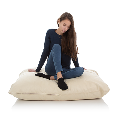 Junge Frau sitzt auf einem 80 x 100 cm grossen Sitzkissen der Farbe beige-weiss