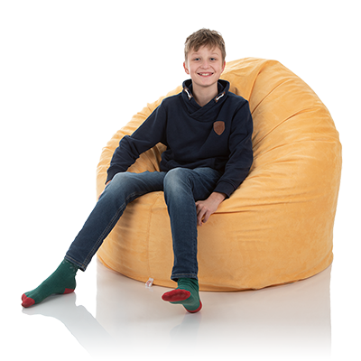 Ein Jugendlicher sitzt in einem bequemen XXL Sitzsack für Kinder gelb